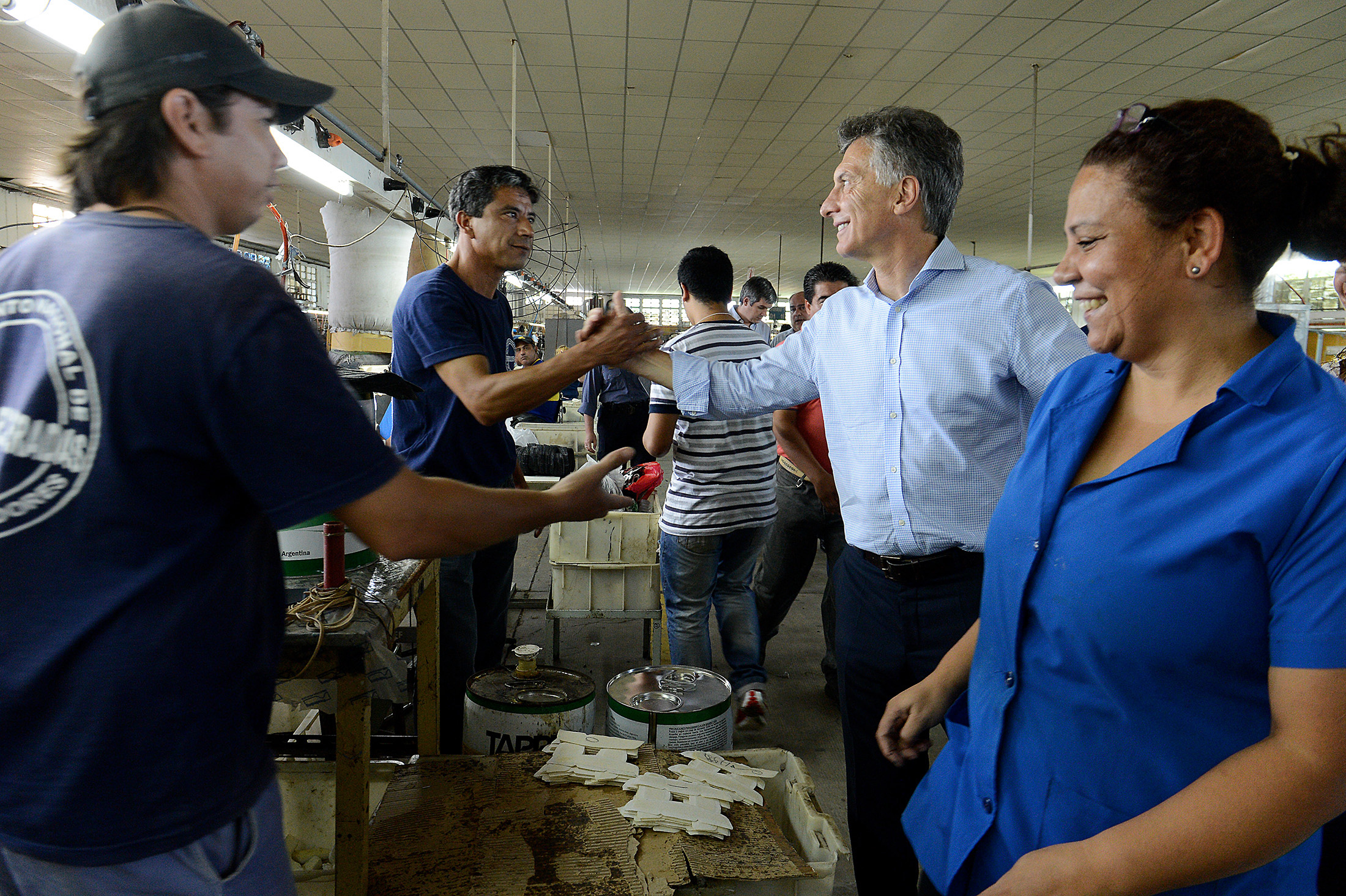 El presidente Mauricio Macri saluda a los trabajadores de una cooperativa de San Luis del Palmar que fabrica indumentaria.